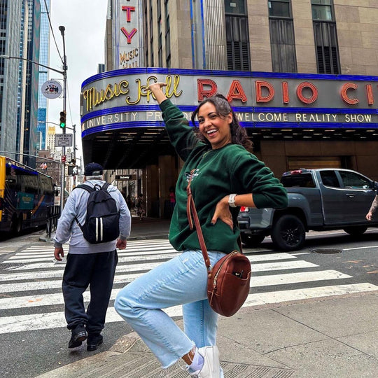 person posing in front of a restaurant wearing a circle crossbody