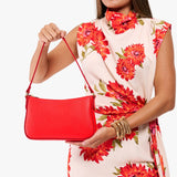 Candy Small | Model carrying petite bean shaped shoulder bag with a zipper closure
