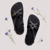 Nero | Person wearing strappy leather sandals with two buckle accents