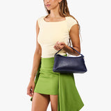 Cobalt | Model holding a dark blue bowler style hand bag 