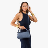 Denim | Model holding a light blue bowler style hand bag 