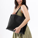 Black Large | Model holding leather tote bag with interior snap key loop