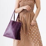 Plum Large | Model holding leather tote bag with interior snap key loop