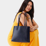 Night Owl Medium | Model holding leather tote bag with interior snap key loop