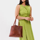 Nutmeg Medium | Model holding leather tote bag with interior snap key loop