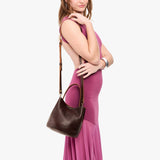 Coldbrew Small | Model wearing symmetrical bucket bag with handle, latch closure, and removable crossbody strap
