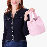 Pinkaboo Small | Model holding symmetrical bucket bag with handle, latch closure, and removable crossbody strap