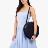 Velvet Blue | Model carrying large circle shaped leather bag with top zipper and carrying strap