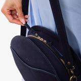 Velvet Blue | Model carrying large circle shaped leather bag with top zipper and carrying strap
