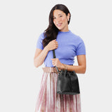 Pebbled--black Small | Model holding slouchy crossbody bag with drawstring closure