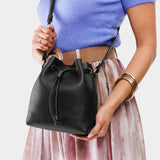 Pebbled--black Small | Model holding slouchy crossbody bag with drawstring closure