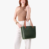Evergreen Classic | Model holding large leather tote bag with sturdy bridle handles and front pocket