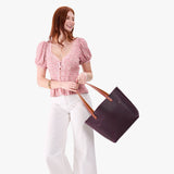 Larkspur Classic | Model holding large leather tote bag with sturdy bridle handles and front pocket