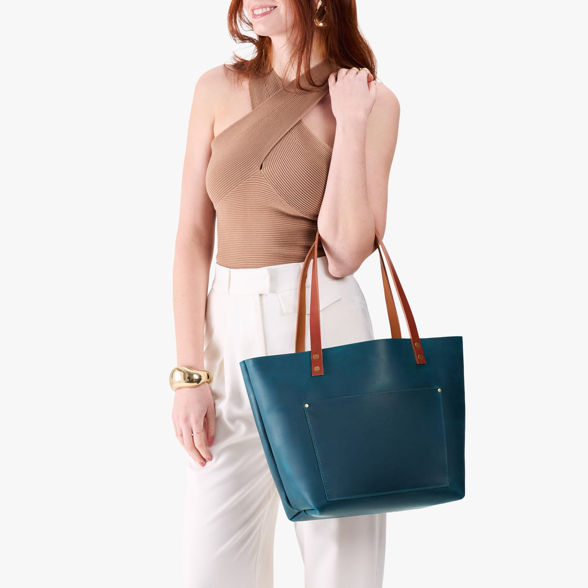 Westward Blue*Classic | Model holding large leather tote bag with sturdy bridle handles and front pocket