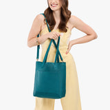 Aquarius Classic | Model holding medium Tote with dual shoulder straps and crossbody strap
