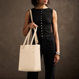 Pebbled Bone Classic | Model holding medium Tote with dual shoulder straps and crossbody strap