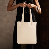 Pebbled Bone Classic | Model holding medium Tote with dual shoulder straps and crossbody strap