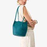 Aquarius Small | Model wearing matching white shirt and skirt carrying petite bucket shaped tote bag with matching leather handles