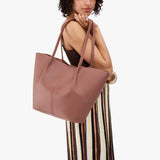 Sunkissed Oversized | Model carrying extra wide bucket shaped tote bag with matching leather handles