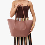 Sunkissed Oversized | Model holding extra wide bucket shaped tote bag with matching leather handles