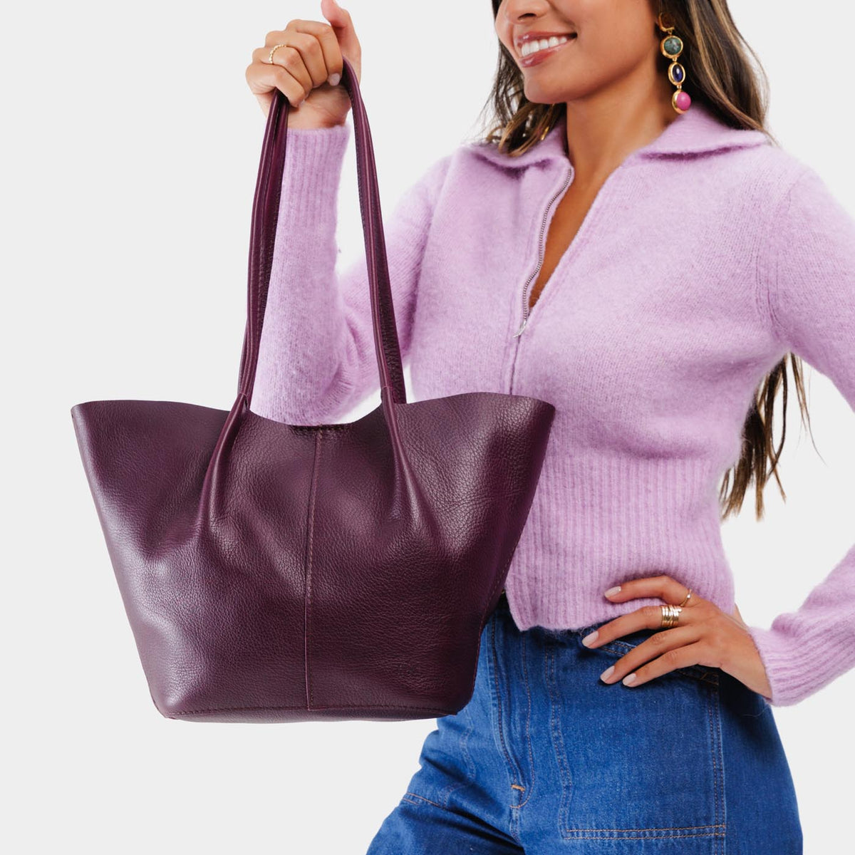 Plum*Large | Model holding wide bucket shaped tote bag with matching leather handles