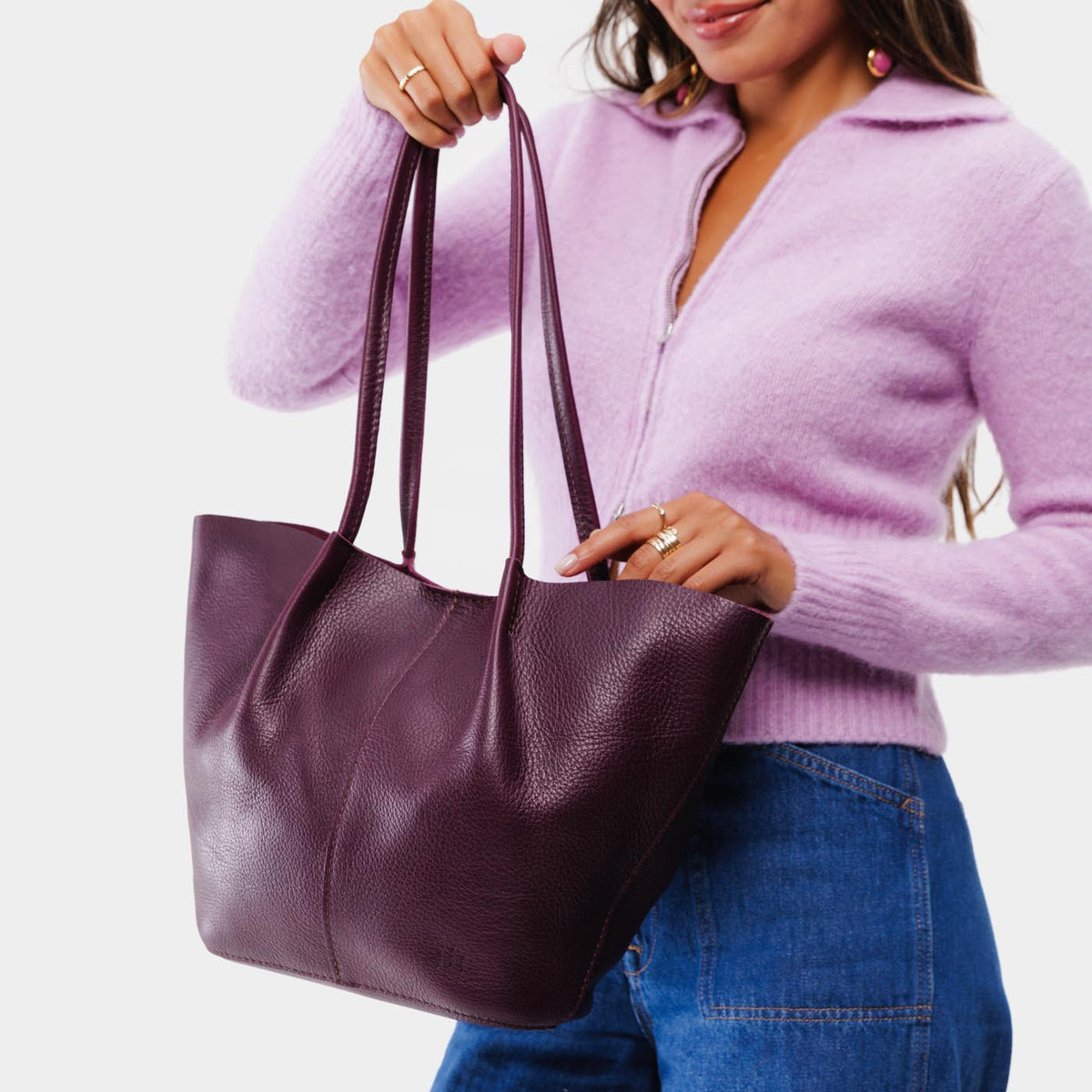 Plum*Large | Model holding wide bucket shaped tote bag with matching leather handles