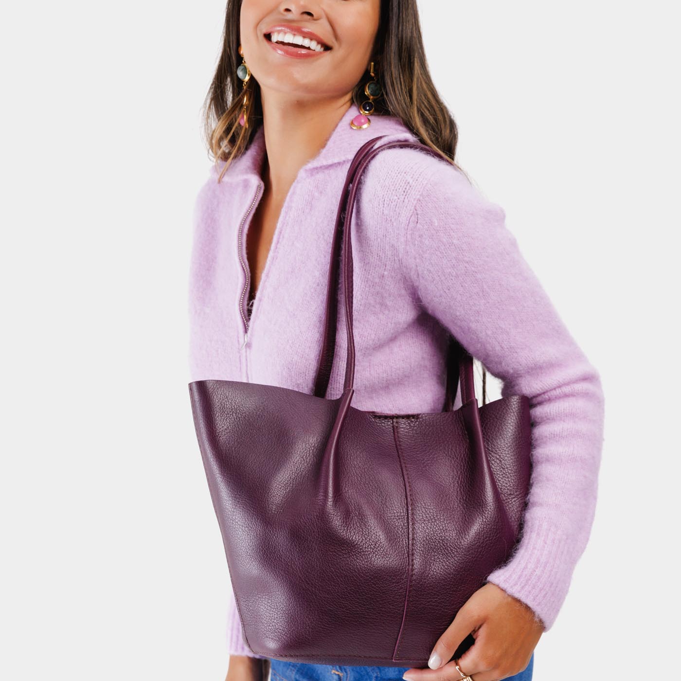 Plum*Large | Model holding wide bucket shaped tote bag with matching leather handles