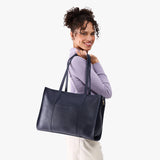 Night Owl Oversized East/West | Model holding structured wide tote bag with overlapping panels and crossbody strap