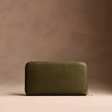 Bay Green | Full zip around wallet with a strap on a brown background