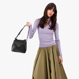 Pebbled--black Small | Model holding symmetrical leather bag with leather drawstring closure and adjustable shoulder strap