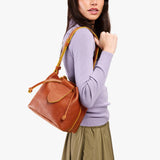 Sienna Small | Model wearing symmetrical leather bag with leather drawstring closure and adjustable shoulder strap
