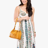 Sunshine Small | Model holding symmetrical leather bag with leather drawstring closure and adjustable shoulder strap