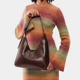 Chocolate Brown | Model wearing structured hobo shoulder bag with adjustable strap and magnetic closure