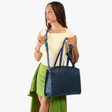 Deep Water Large | Model carrying leather tote bag with handles, adjustable crossbody strap, and two back pockets