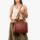 Nutmeg Large | Model carrying leather tote bag with handles, adjustable crossbody strap, and two back pockets