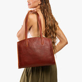 Nutmeg Large | Model carrying leather tote bag with handles, adjustable crossbody strap, and two back pockets