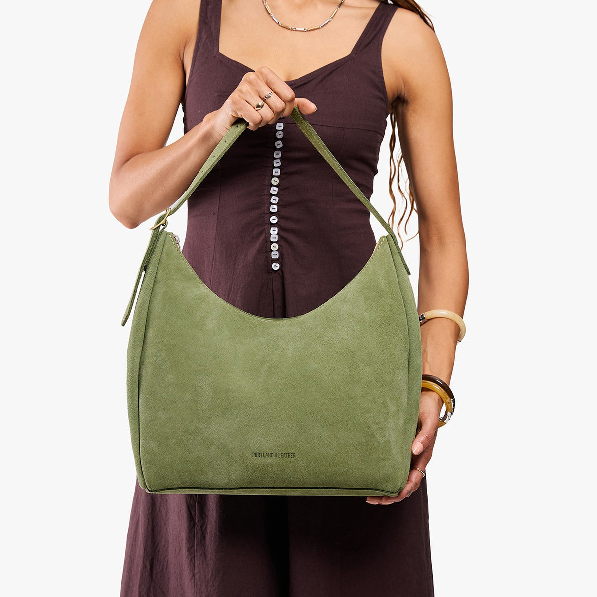 Laurel*Large | Model holding u-shaped, flat-bottomed leather shoulder bag with adjustable strap
