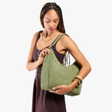 Laurel Large | Model holding u-shaped, flat-bottomed leather shoulder bag with adjustable strap