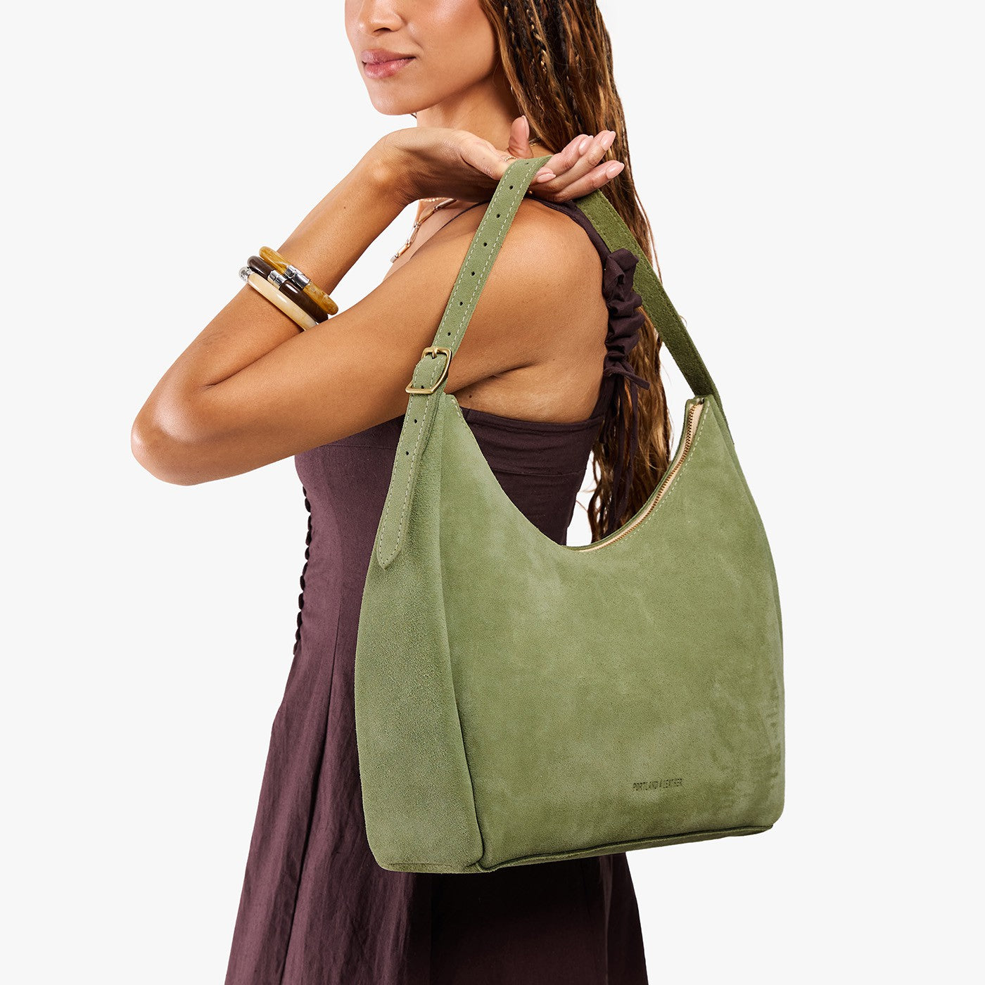 Laurel*Large | Model holding u-shaped, flat-bottomed leather shoulder bag with adjustable strap