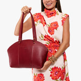 Chili Red Large | Model holding a half circle crossbody bag with handles and removable crossbody strap