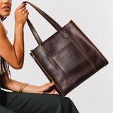 Grizzly North/South | Model holding structured large tote bag with overlapping panels and crossbody strap