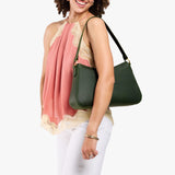 Evergreen Large | Model holding a bean shaped shoulder bag with a zipper closure