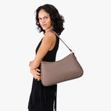 Sparrow Large | Model holding a bean shaped shoulder bag with a zipper closure
