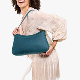 Westward Blue Large | Model holding a bean shaped shoulder bag with a zipper closure