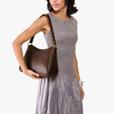 Coldbrew Large | Model holding a bean shaped shoulder bag with a zipper closure