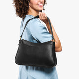 Pebbled--black Large | Model holding a bean shaped shoulder bag with a zipper closure