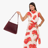 Cabernet Large | Model holding a triangular shoulder bag with antiqued brass finished 