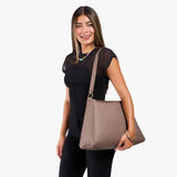 Sparrow Large | Model holding a triangular shoulder bag with antiqued brass finished 
