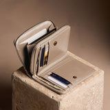 Satine | Open wallet with card and storage pockets on a light brown background