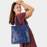 Cowboy Blue North/South | Model wearing structured large tote bag with overlapping panels and crossbody strap